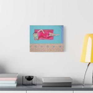 Canvas print of a woman in a pink dress on a blue background, displayed on a wall above a desk.
