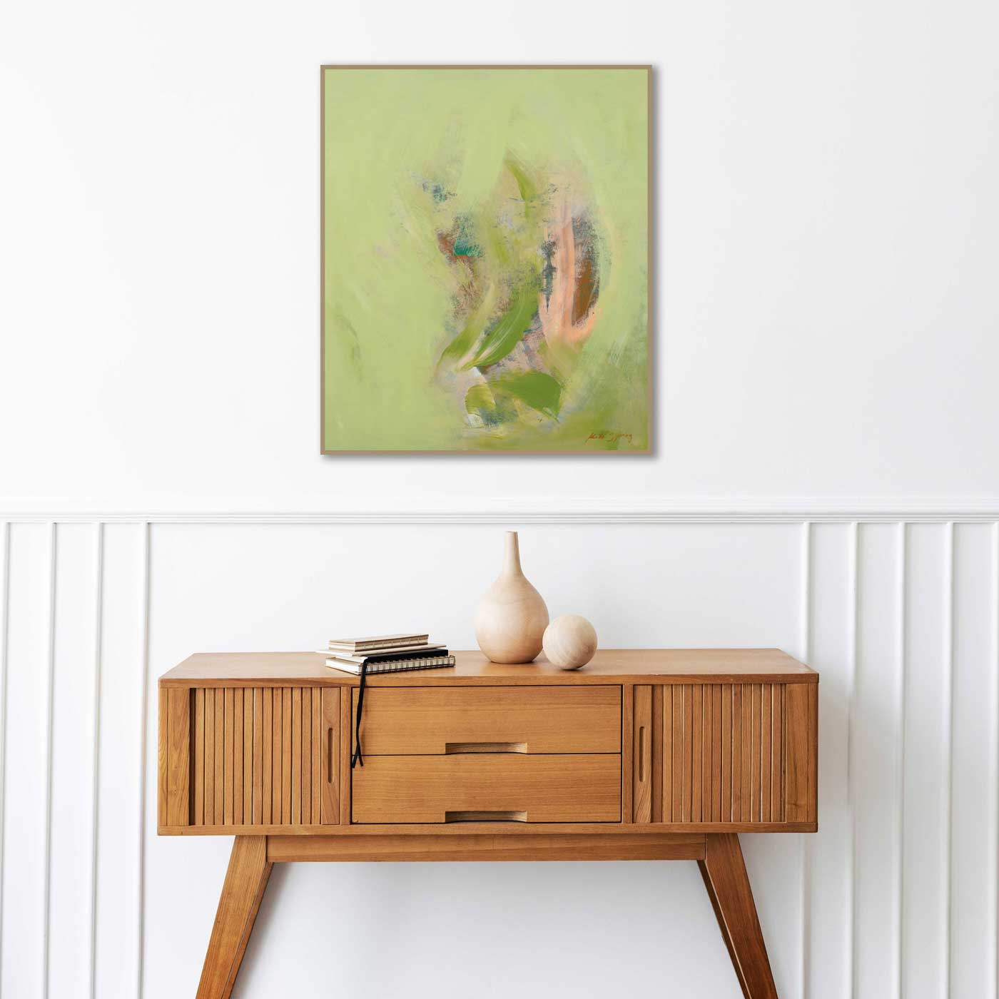 Wooden console table with decorative items and a framed abstract painting on a white wall.