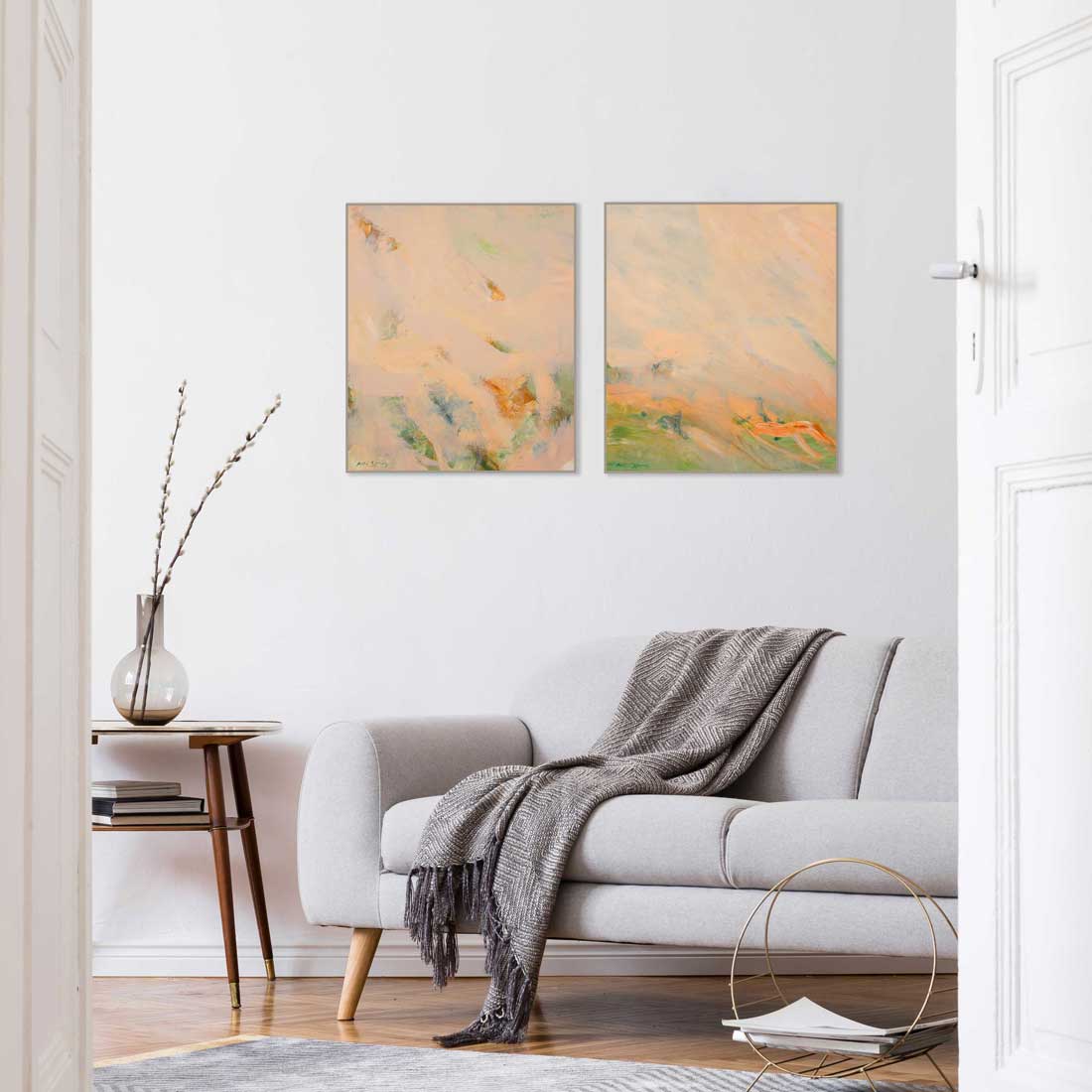 Living room with a sofa, coffee table, and two abstract paintings on the wall.