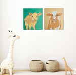 Load image into Gallery viewer, Two wall art prints of cows in a room with decorative items.
