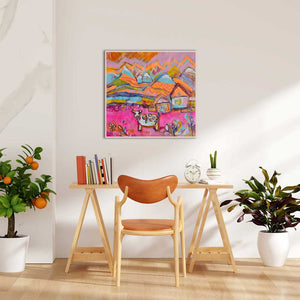 Colorful abstract painting on a wall above a wooden table with a chair, plants, and books.