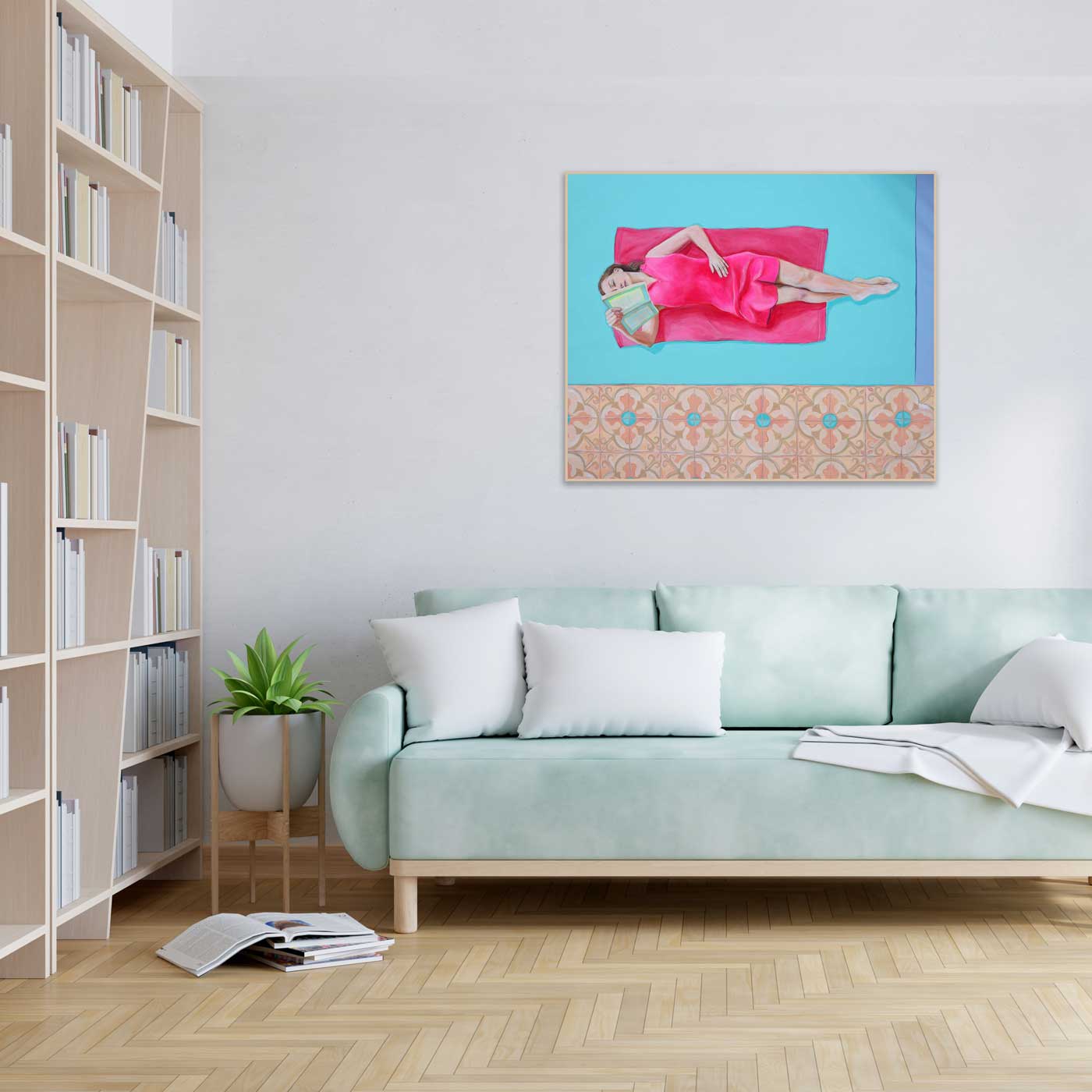 Living room with a light blue sofa, bookshelf, and wall art.