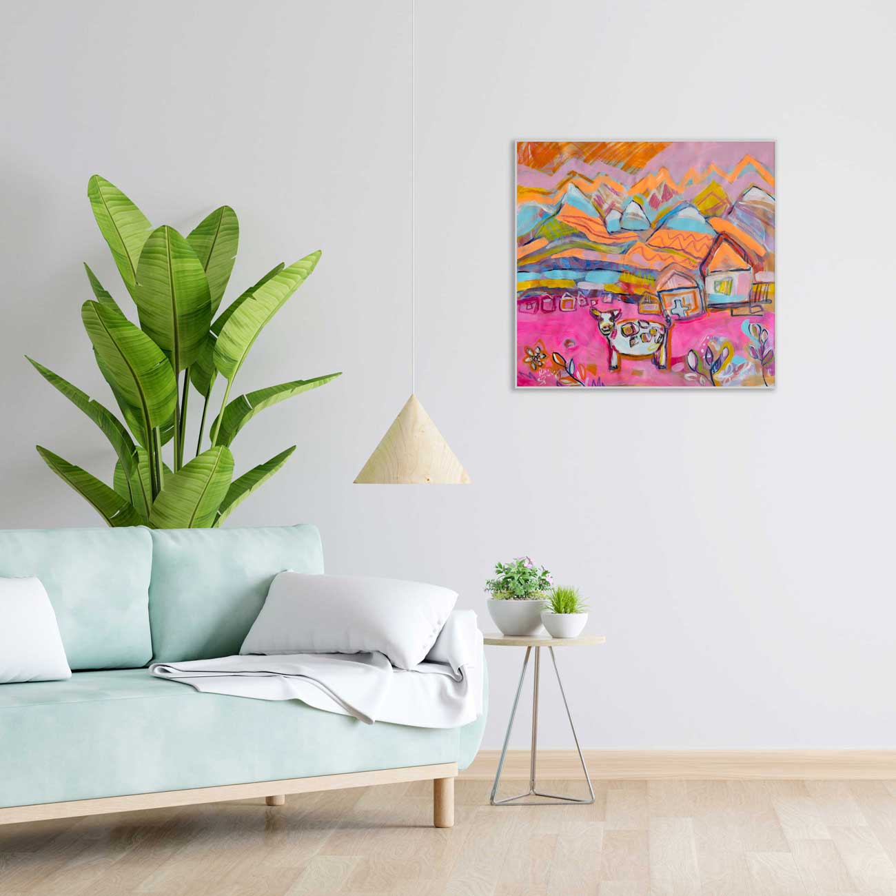 Living room with a light blue sofa, green plant, and colorful abstract painting on the wall.