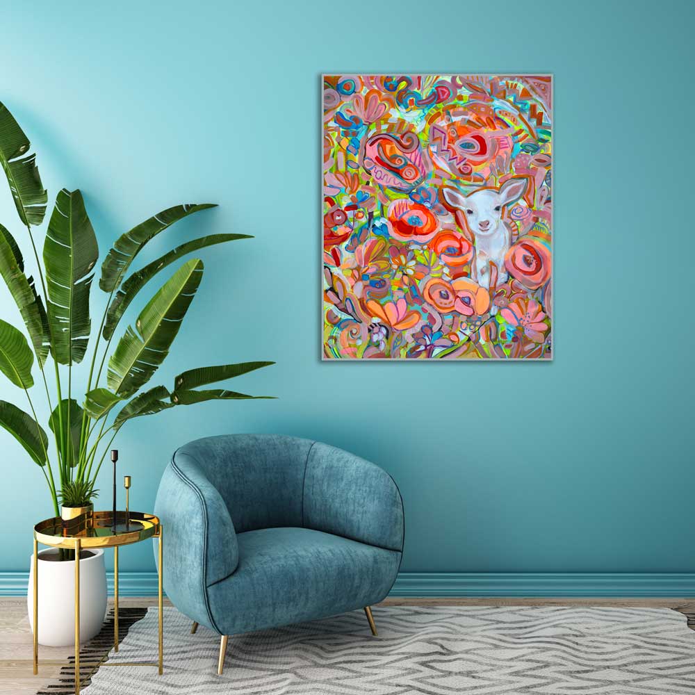 Colorful abstract painting of a lamb with flowers on a blue wall above a blue armchair.