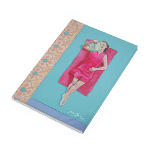 Notebook with a colorful design on the cover featuring a woman in a pink dress.