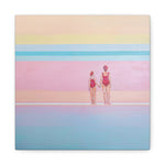 Load image into Gallery viewer, A canvas wall art print featuring a mother and daughter, standing on a beach with pastel-colored water and sky in the background.
