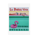 Load image into Gallery viewer, Vintage-style poster with a woman on an inflatable flamingo, text &#39;La Dolce Vita&#39; and &#39;Ticino Svizzera&#39;.
