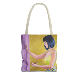 A tote bag featuring a vibrant acrylic painting of a woman with black hair, yellow top, and a purple background, with a small bird in her hand.
