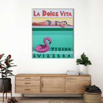 Load image into Gallery viewer, Poster of a woman lying on a pool float with 'La Dolce Vita' text in a room with a wooden sideboard and plants.

