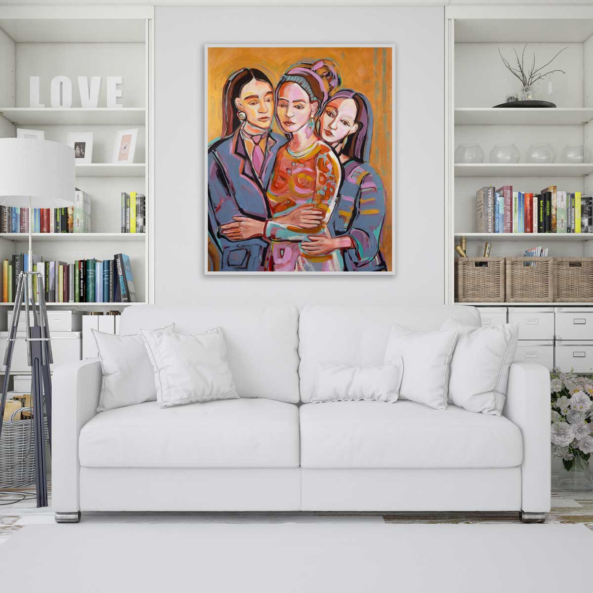 White sofa in a living room with a colorful painting of three people above it.