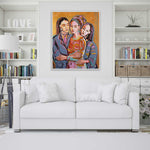 Load image into Gallery viewer, White sofa in a living room with a colorful painting of three people above it.
