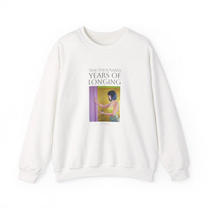 A person wearing a light-colored sweatshirt with text and a graphic design in the center.